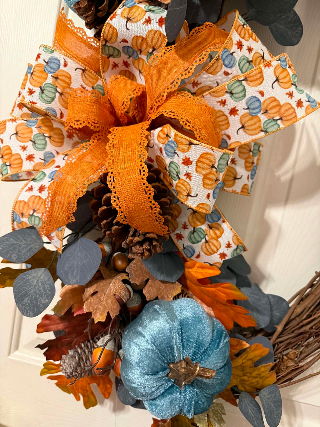 Blue Pumpkin Fall Oval Grapevine Wreath on white door - full view