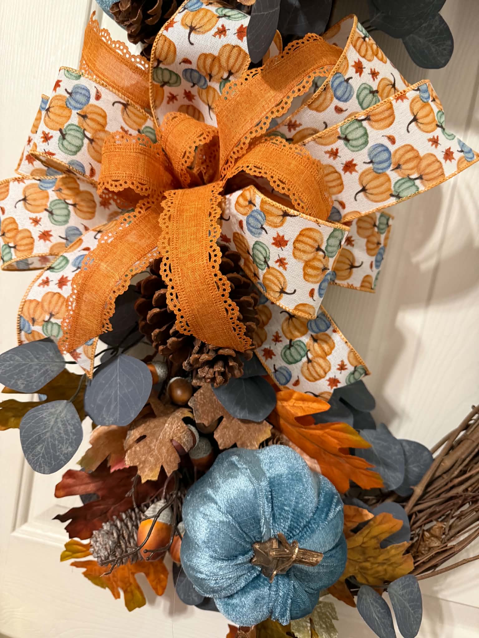 Blue Pumpkin Fall Oval Grapevine Wreath on white door - full view