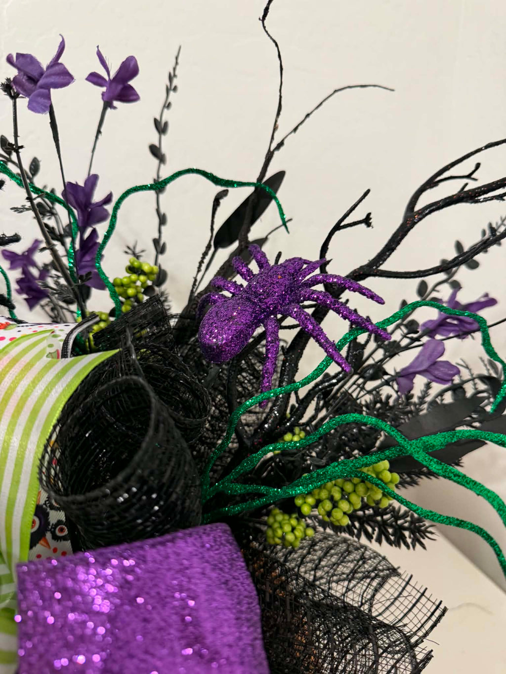 Detail of purple glitter spider and green curly wire stems