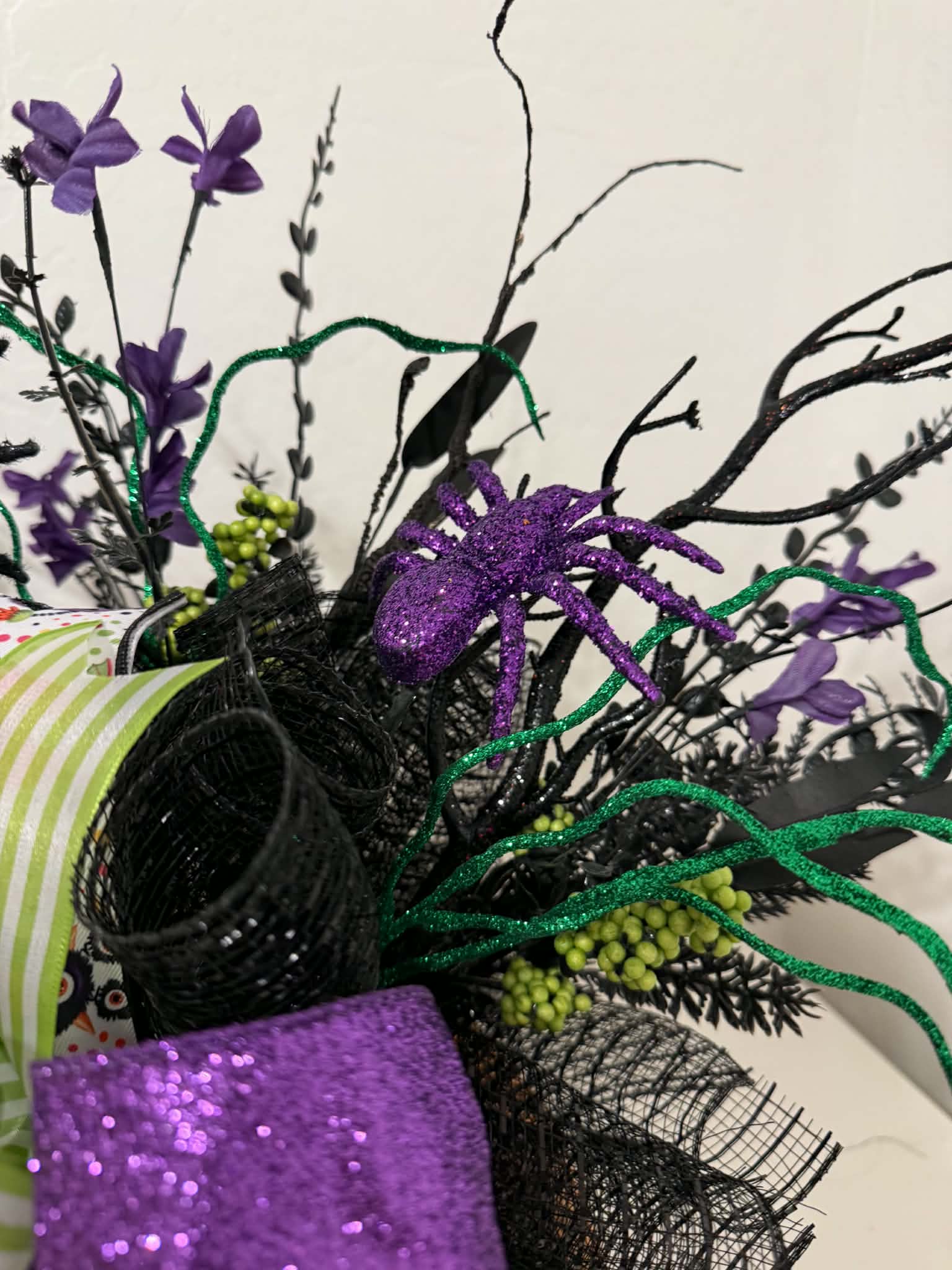 Detail of purple glitter spider and green curly wire stems