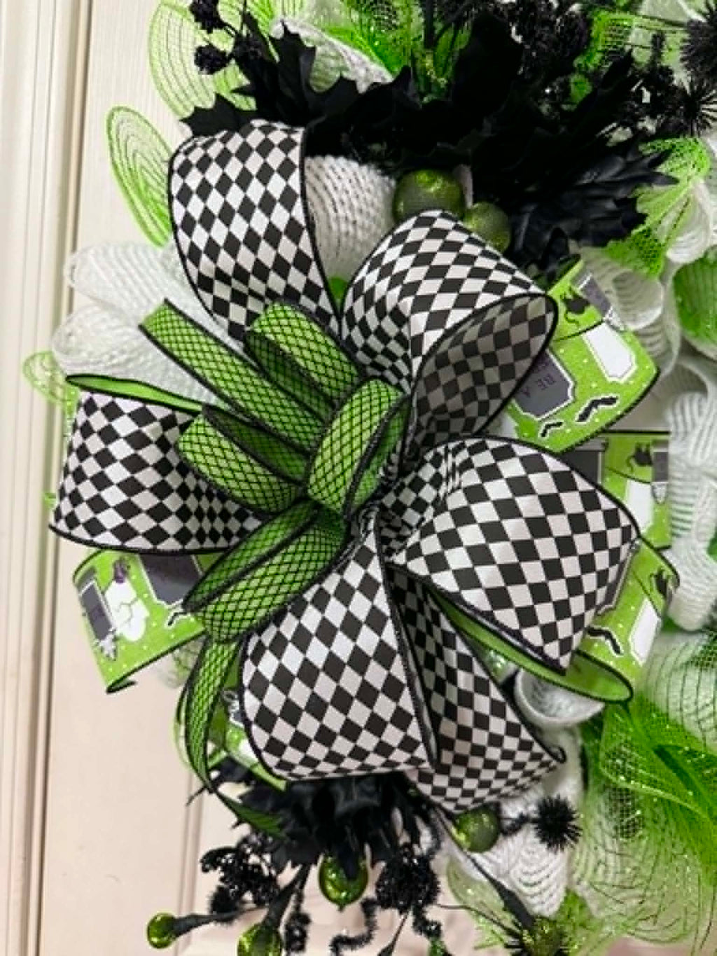 Close-up of black and white checkered bow detail on lime green Halloween wreath