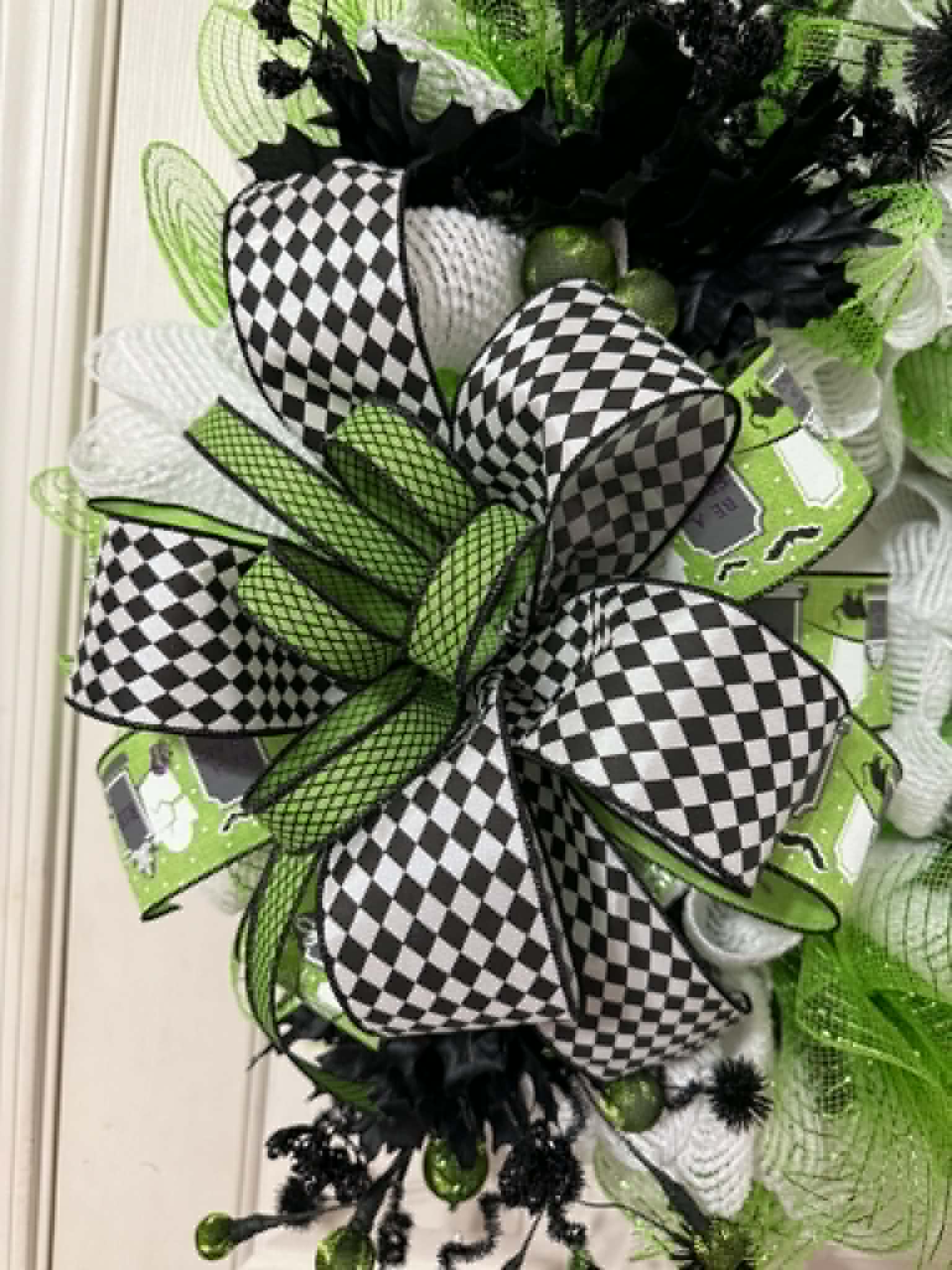 Close-up of black and white checkered bow detail on lime green Halloween wreath